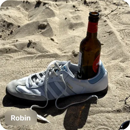 photo of a beer bottle in a shoe on the beach