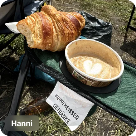 photo of a coffee and croissant ina camping chair